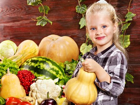Little girl with vegetable on kitchen.の写真素材