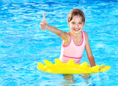 Children sitting on inflatable ring in swimming pool.の写真素材