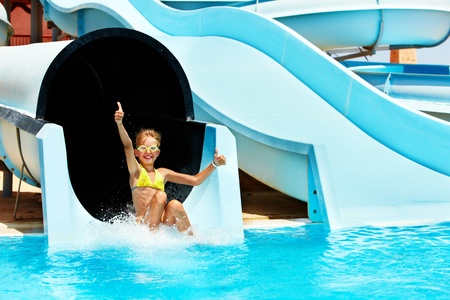 Child on water slide at aquapark. Summer holiday.の写真素材