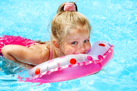 Child sitting on inflatable ring in swimming pool.の写真素材