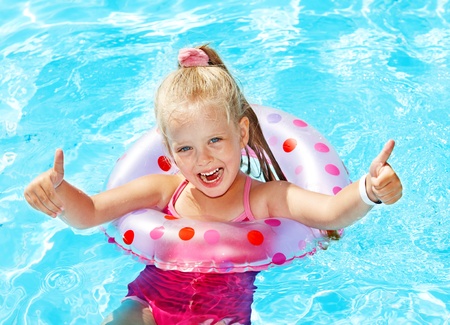 Child sitting on inflatable ring in swimming pool.の写真素材