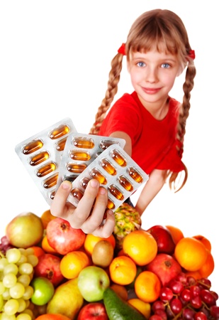 Child with fruit and vitamin pill. Isolated.の写真素材