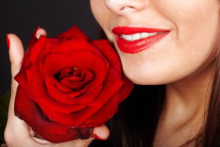 Girl with rose on red background. Valentines day.の写真素材