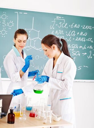 Female chemistry student with flask in classroom.の写真素材
