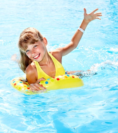 Child sitting on inflatable ring in swimming pool.の写真素材
