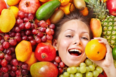 Young woman in group of fruit. Healthcare.の写真素材