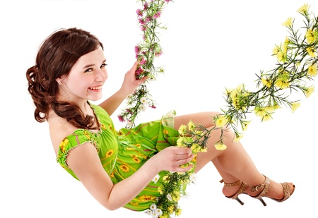 Beautiful girl swinging on flower swing. Isolated.の写真素材