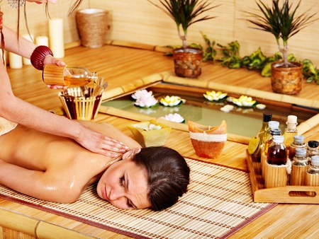 Young woman getting massage in bamboo spa.の写真素材