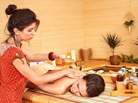 Young woman getting massage in bamboo spa.の写真素材
