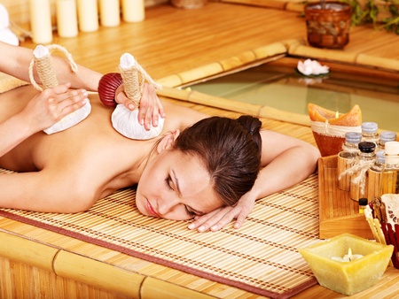 Young woman getting massage in bamboo spa.の写真素材