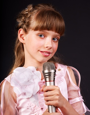 Singing of little girl in microphone.の写真素材