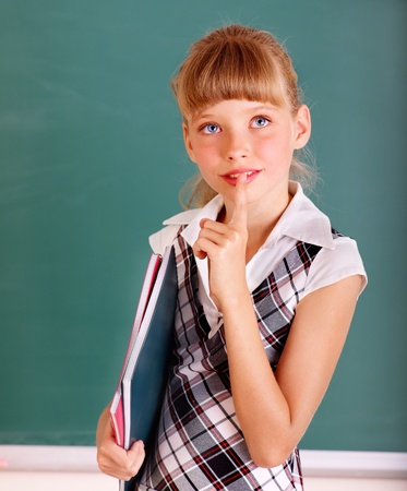 Thinking school child near blackboard.の写真素材