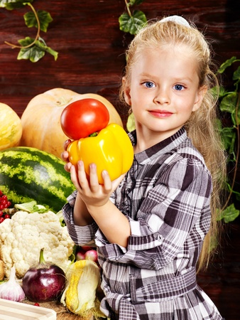 Little girl with vegetable on kitchen.の写真素材