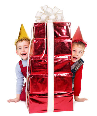 Child in party hat with gold gift box on birthday.  Isolated.の写真素材