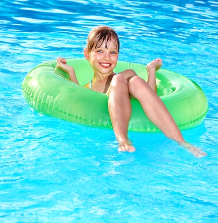 Little girl sitting on inflatable ring in swimming pool.の写真素材