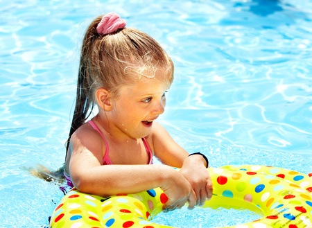 Child sitting on inflatable ring in swimming pool.の写真素材