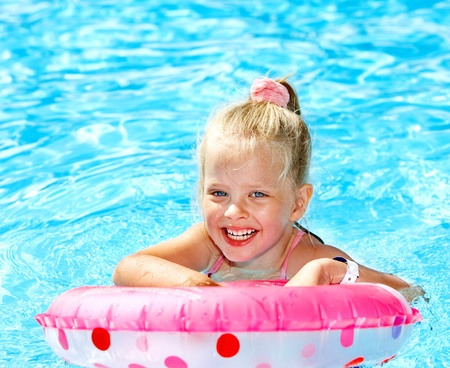 Little girl sitting on inflatable ring in swimming pool.の写真素材