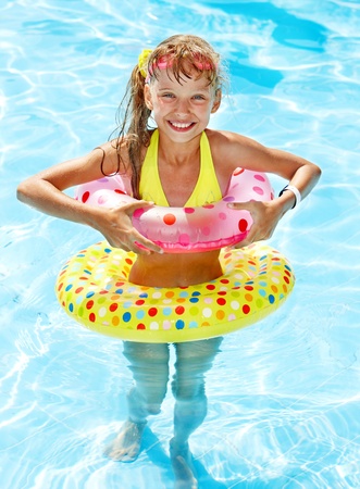 Child sitting on inflatable ring in swimming pool.の写真素材