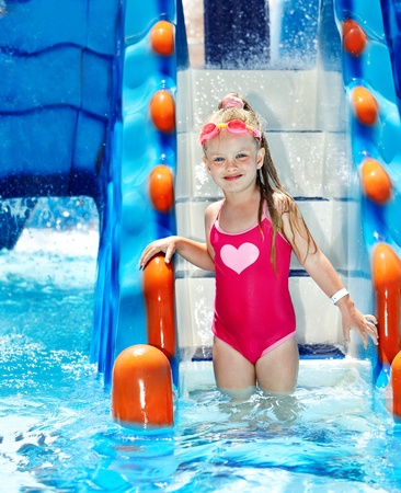 Little girl on water slide at aquapark.の写真素材
