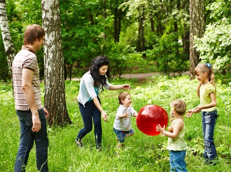 Outdoor happy family with children plaing ball  on green grass.の写真素材