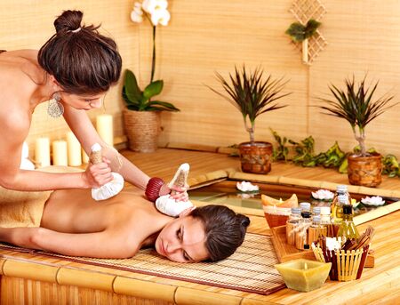 Young woman getting massage in bamboo spa.の写真素材