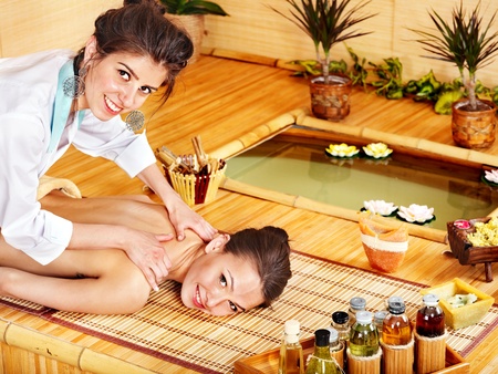 Young woman getting massage in bamboo spa.の写真素材