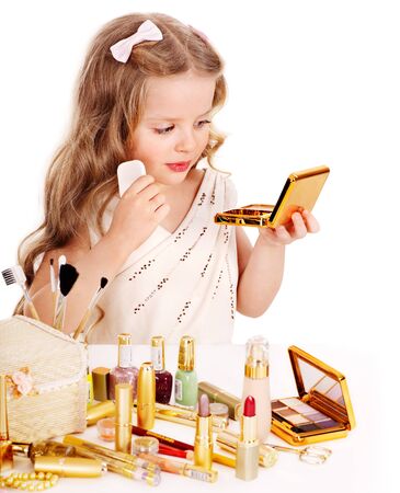 Child cosmetics. Little girl applying make up.の写真素材