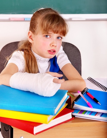 Disabled child with broken arm in classroom.の写真素材