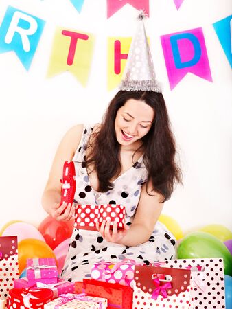 Young woman holding gift box at birthday party.の写真素材