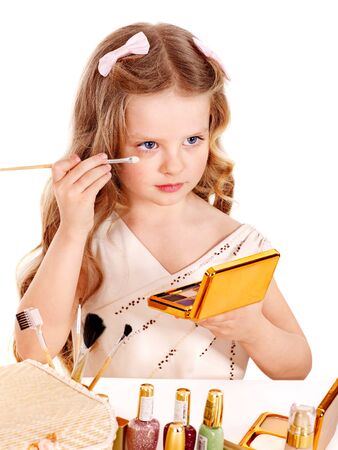 Child cosmetics. Little girl applying make up.の写真素材