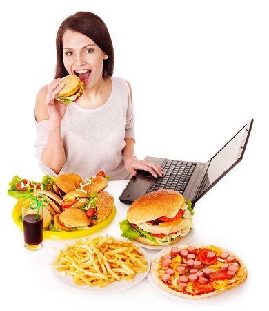 Woman eating fast food at work. Isolated.の写真素材