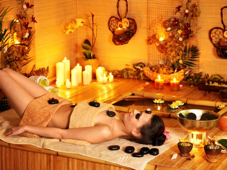 Woman getting stone therapy massage in bamboo spa.の写真素材