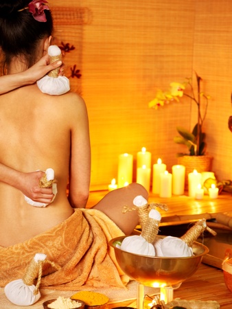 Young woman getting thai herbal massage ball.の写真素材