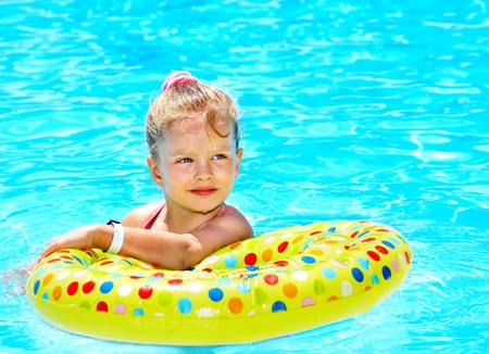 Child sitting on inflatable ring in swimming pool.の写真素材