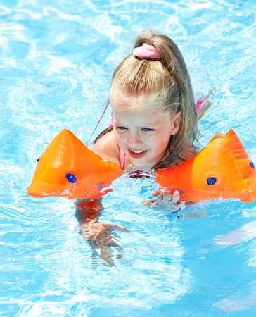 Child with armbands playing in swimming pool. Summer outdoor.の写真素材