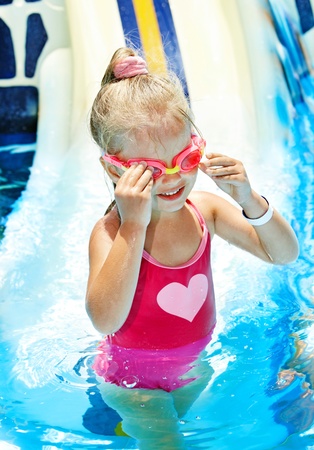 Little girl on water slide at aquapark.の写真素材