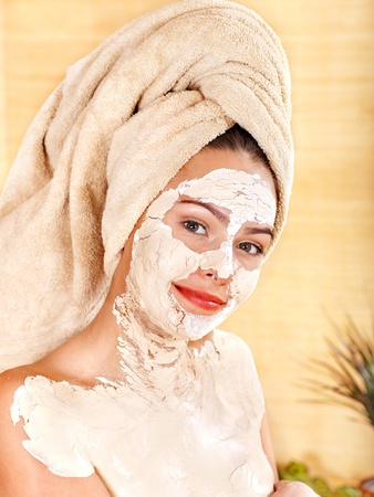 Beautiful girl having clay body mask apply by beautician.の写真素材