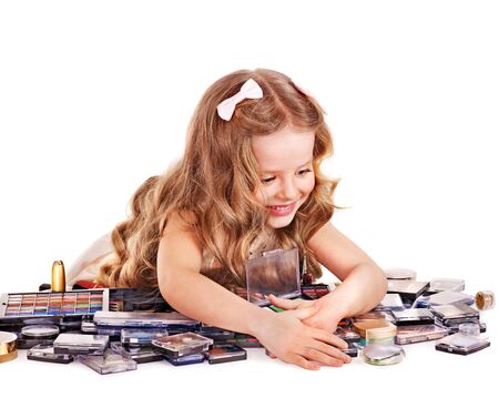 Child cosmetics. Little girl applying make up.の写真素材