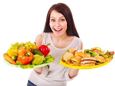 Woman choosing between fruit and hamburger. Isolated.の写真素材