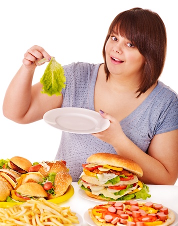 Woman choosing between fruit and hamburger. Isolated.の写真素材