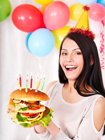 Woman eating hamburger at birthday. Isolated.の写真素材