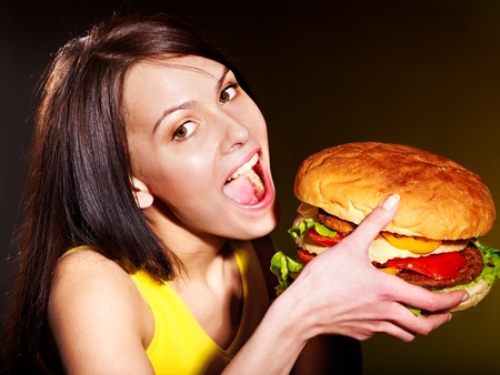 Slim woman eating hamburger.の写真素材