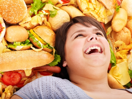 Happy overweight woman with fast food.の写真素材