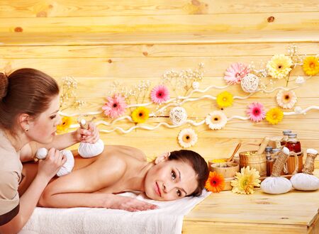Woman getting herbal ball massage  in spa resort.の写真素材