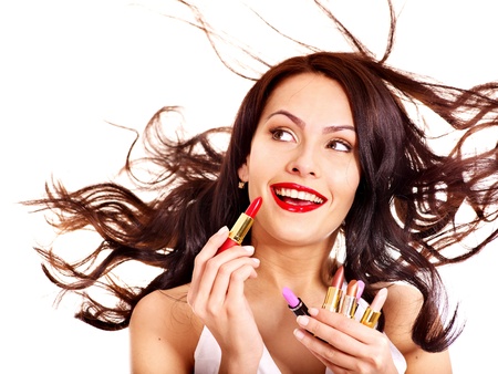 Girl applying makeup. Girl chooses lipstick.の写真素材