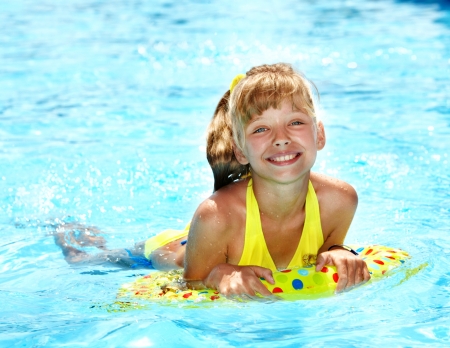Child sitting on inflatable ring in swimming pool.の写真素材