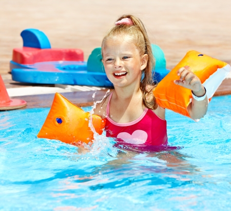 Child with armbands playing in swimming pool. Summer outdoor.の写真素材