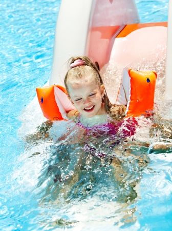 Child on water slide at aquapark. Summer outdoor.の写真素材
