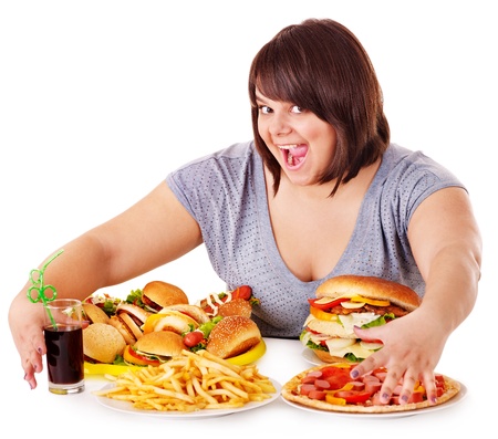 Overweight woman eating fast food.の写真素材