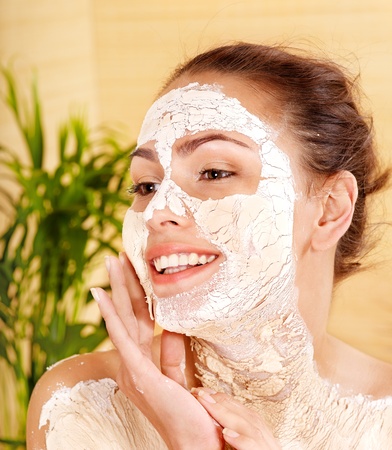 Woman with clay  facial mask in spa resort.の写真素材